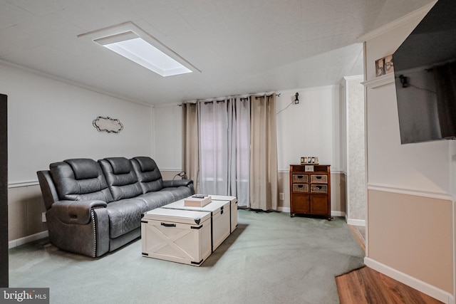 living room featuring carpet floors, a skylight, and crown molding