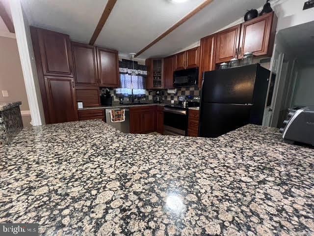 kitchen with black appliances, sink, decorative backsplash, beamed ceiling, and kitchen peninsula