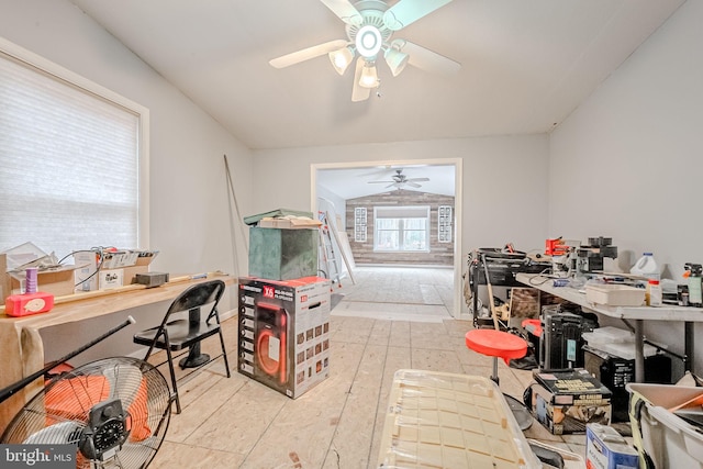 interior space featuring ceiling fan, light tile patterned floors, and vaulted ceiling