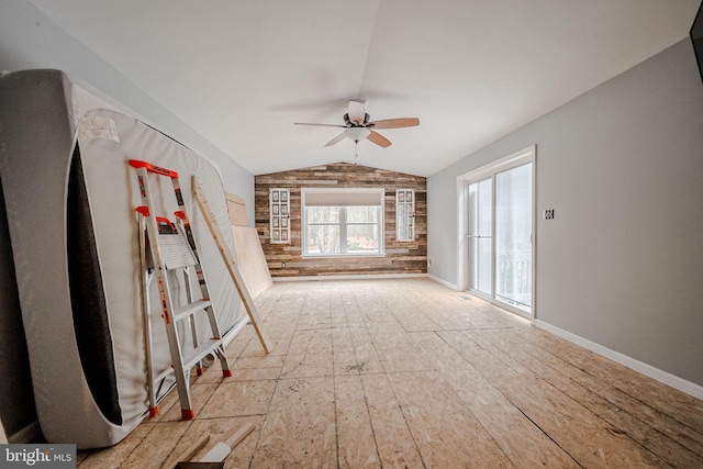 empty room with ceiling fan, light hardwood / wood-style flooring, and vaulted ceiling