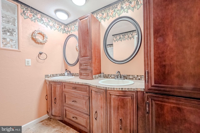 bathroom with tile patterned floors, vanity, and a textured ceiling