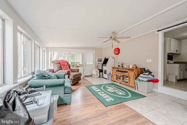 living room with lofted ceiling, ceiling fan, and light wood-type flooring