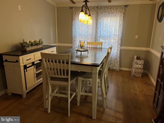 dining room with dark hardwood / wood-style flooring and ornamental molding