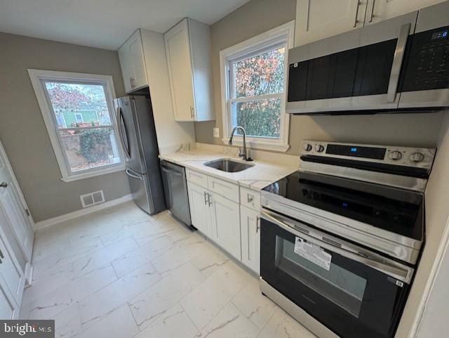 kitchen with white cabinets, stainless steel appliances, and sink