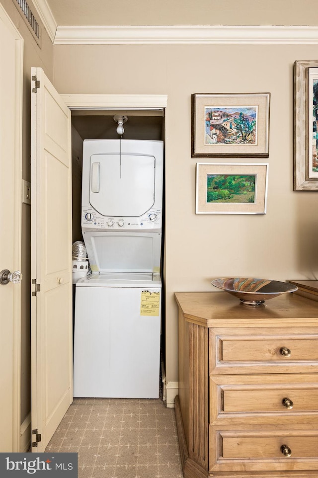 laundry room with crown molding and stacked washer and dryer