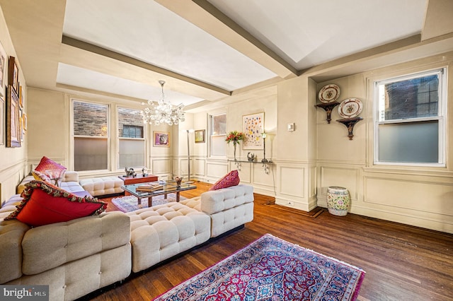 living room with beam ceiling, wainscoting, an inviting chandelier, wood finished floors, and a decorative wall