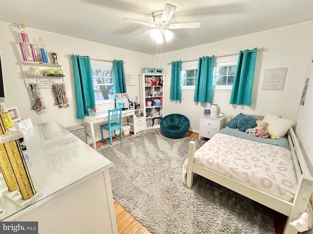 bedroom featuring wood-type flooring, multiple windows, and ceiling fan