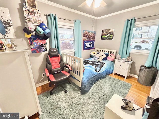 bedroom featuring ceiling fan, hardwood / wood-style floors, and crown molding