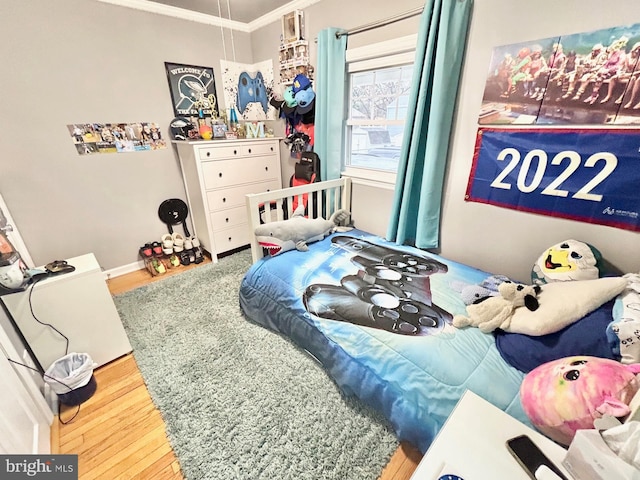 bedroom with wood-type flooring and ornamental molding