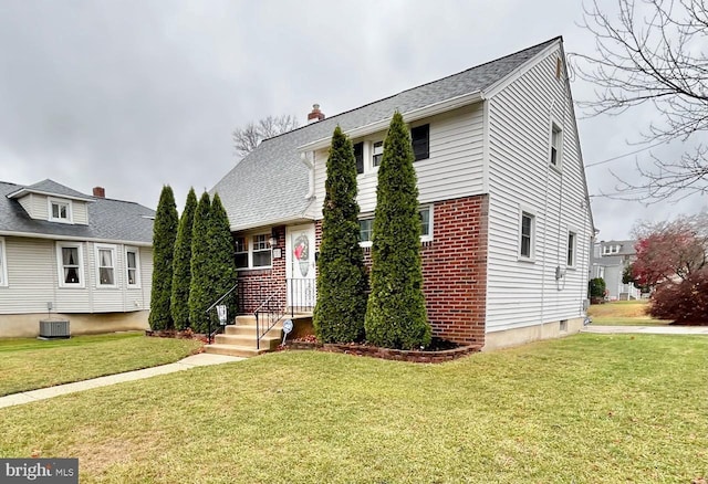 view of front facade with a front yard and central air condition unit