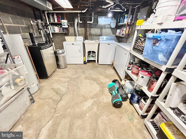 basement featuring gas water heater, washer and clothes dryer, and sink