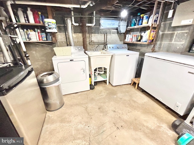 washroom with washing machine and clothes dryer and sink