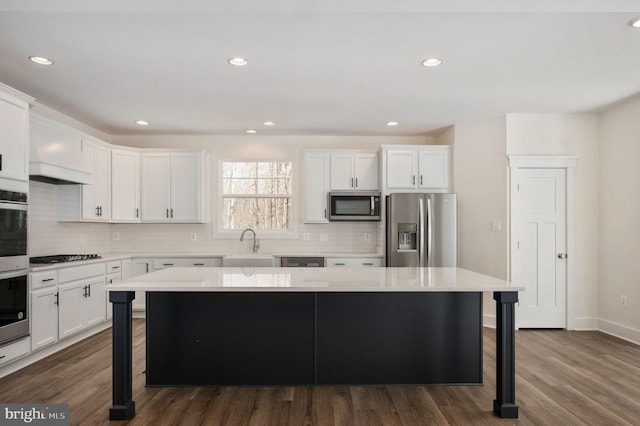 kitchen featuring a breakfast bar area, appliances with stainless steel finishes, sink, and a center island