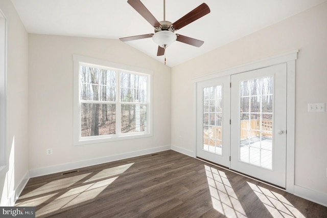 spare room with vaulted ceiling, ceiling fan, a healthy amount of sunlight, and dark wood-type flooring