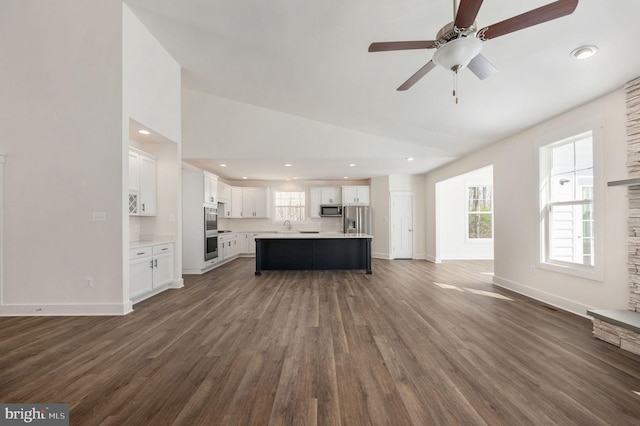 unfurnished living room featuring vaulted ceiling, ceiling fan, and dark hardwood / wood-style flooring