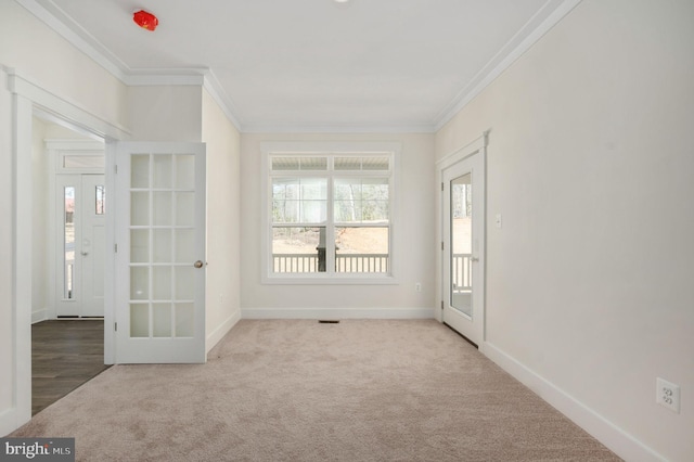 carpeted spare room featuring ornamental molding and french doors