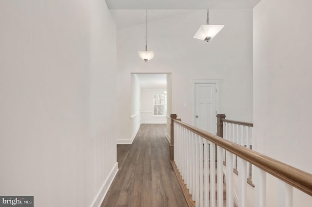 corridor featuring vaulted ceiling and dark wood-type flooring