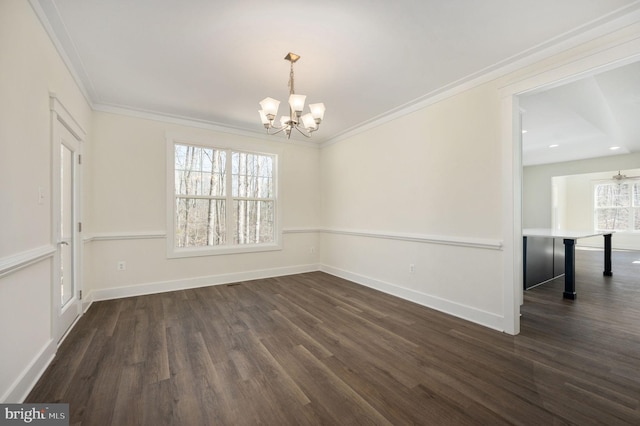 unfurnished room with dark hardwood / wood-style flooring, ornamental molding, a notable chandelier, and a healthy amount of sunlight