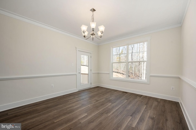 empty room with a wealth of natural light, ornamental molding, and a chandelier