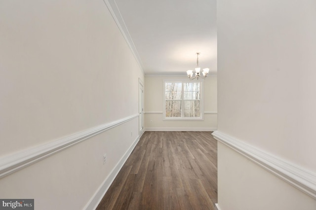 spare room with crown molding, a chandelier, and hardwood / wood-style floors