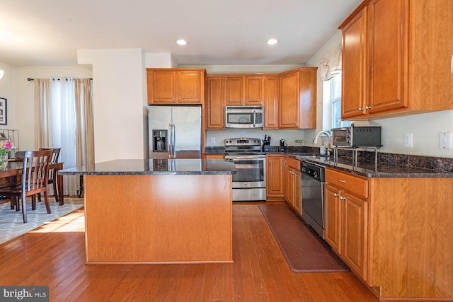 kitchen with sink, a center island, light hardwood / wood-style floors, and appliances with stainless steel finishes