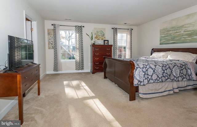 bedroom with light carpet and multiple windows