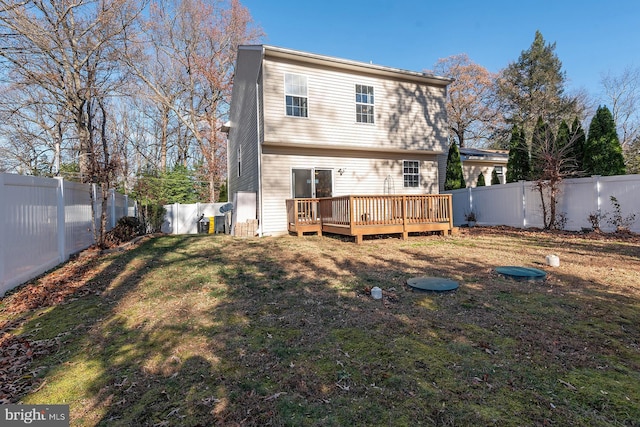 rear view of property featuring a deck and a lawn