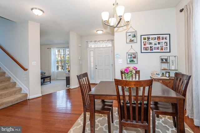 dining space featuring hardwood / wood-style flooring and a notable chandelier