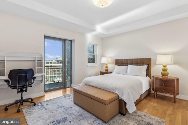 bedroom featuring wood-type flooring and access to outside