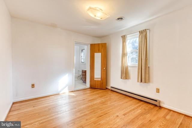 spare room with light hardwood / wood-style floors and a baseboard heating unit