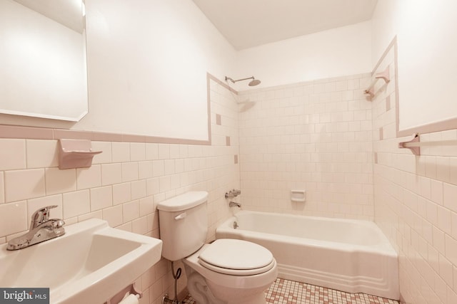 full bathroom featuring tiled shower / bath, sink, tile patterned flooring, toilet, and tile walls