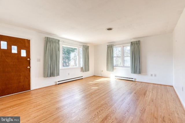 foyer with light hardwood / wood-style floors, plenty of natural light, and a baseboard heating unit