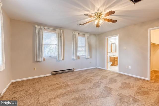 unfurnished bedroom featuring a walk in closet, ceiling fan, baseboard heating, carpet floors, and a closet