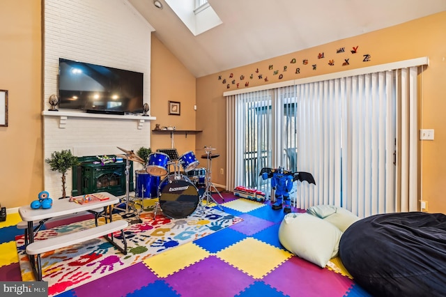 bedroom featuring a fireplace and vaulted ceiling with skylight