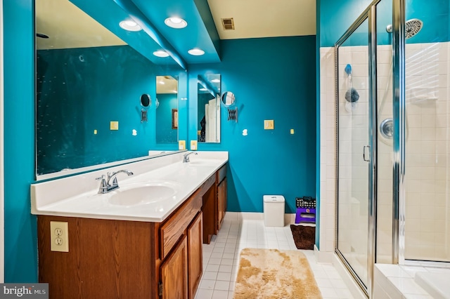 bathroom featuring tile patterned flooring, vanity, and a shower with shower door