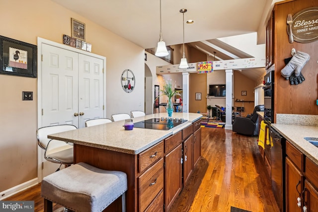 kitchen with a breakfast bar area, dark hardwood / wood-style flooring, a kitchen island, and hanging light fixtures