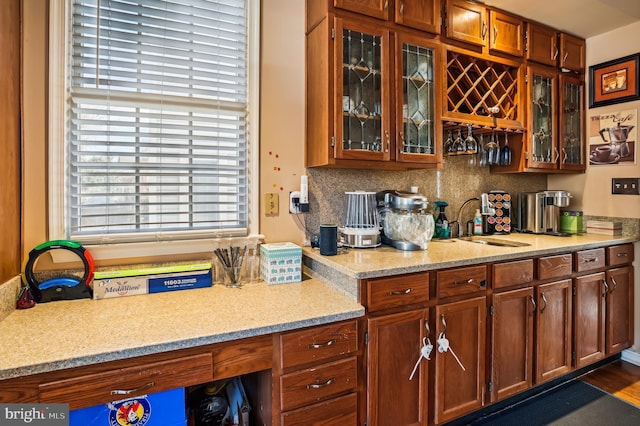 kitchen with backsplash, light stone counters, dark hardwood / wood-style flooring, and sink