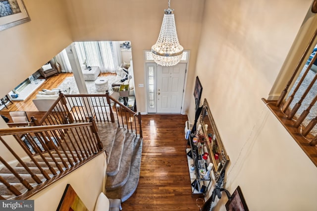 foyer entrance with a notable chandelier, dark hardwood / wood-style floors, and a healthy amount of sunlight