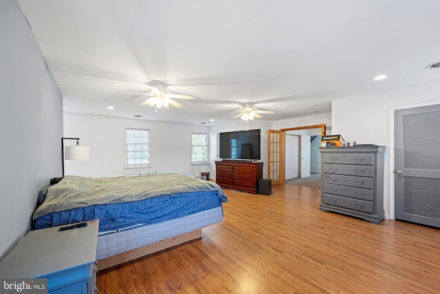 bedroom with ceiling fan, light hardwood / wood-style floors, and french doors