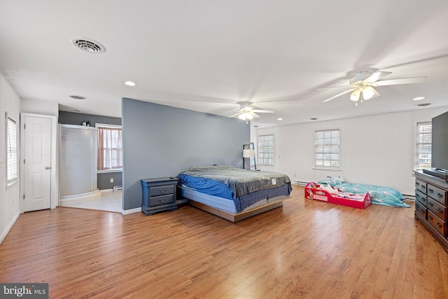 bedroom with light wood-type flooring, multiple windows, and ceiling fan