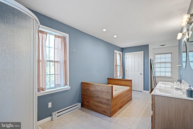 bathroom with tiled bath, a healthy amount of sunlight, vanity, and a baseboard radiator