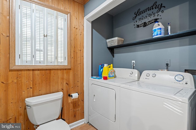 laundry room with wooden walls and independent washer and dryer