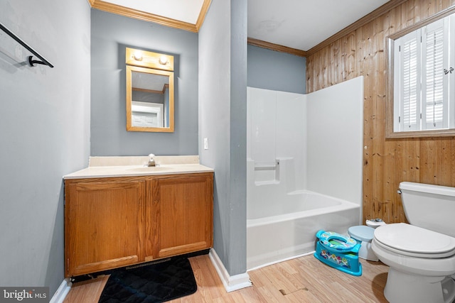 full bathroom featuring ornamental molding, shower / bathing tub combination, hardwood / wood-style flooring, toilet, and wood walls