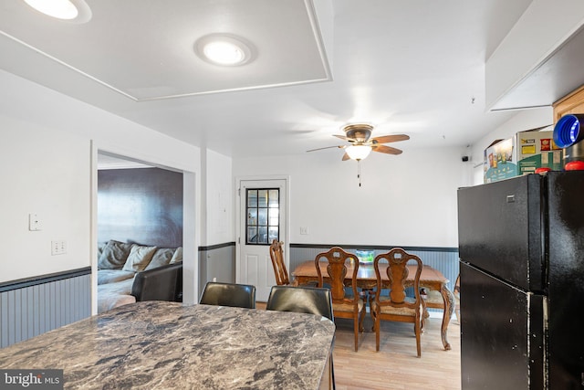 dining space with light hardwood / wood-style floors and ceiling fan