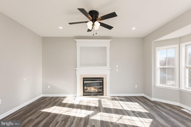 unfurnished living room with dark hardwood / wood-style floors and ceiling fan