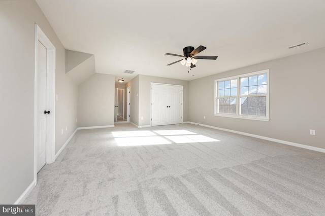 interior space with ceiling fan, light colored carpet, and lofted ceiling