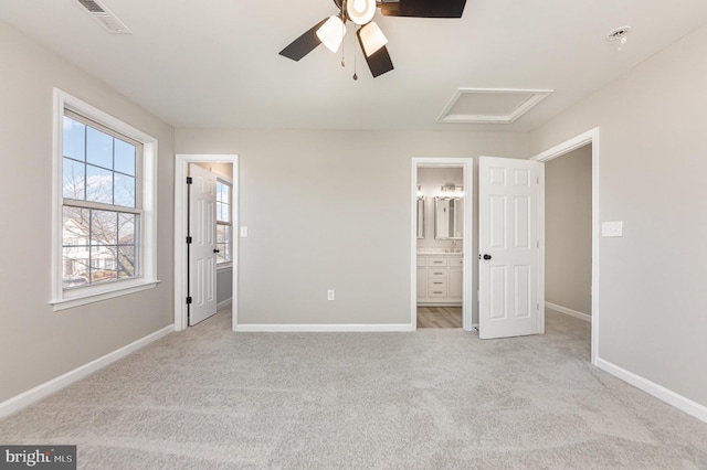 unfurnished bedroom with ensuite bathroom, ceiling fan, and light colored carpet