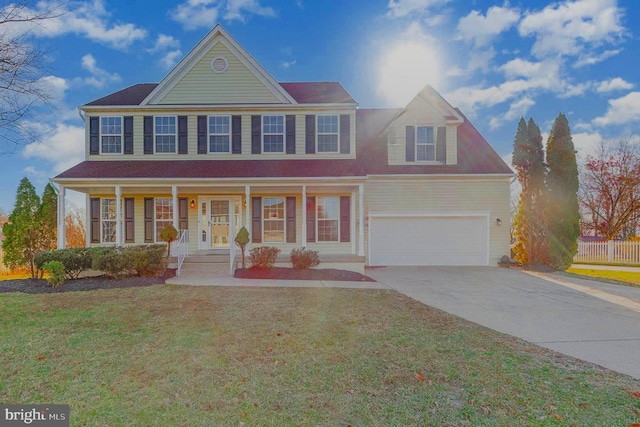 view of front of home with a front yard, a porch, and a garage