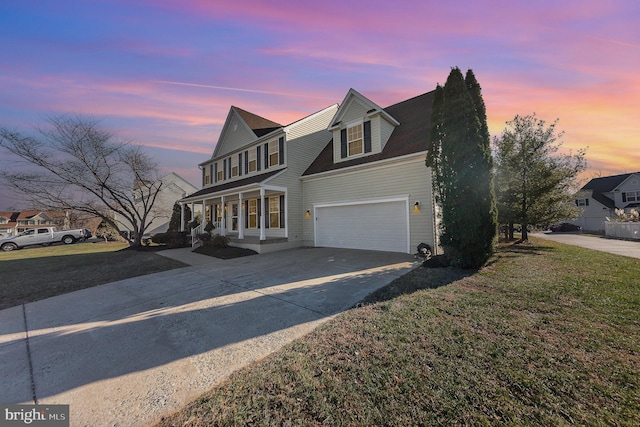 view of front of property featuring a yard, covered porch, and a garage