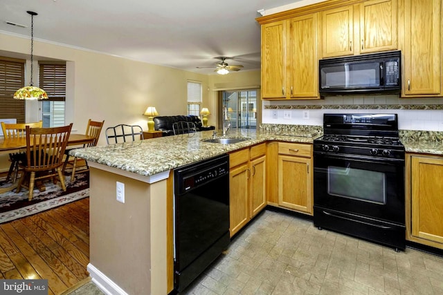 kitchen featuring sink, hanging light fixtures, kitchen peninsula, light hardwood / wood-style floors, and black appliances